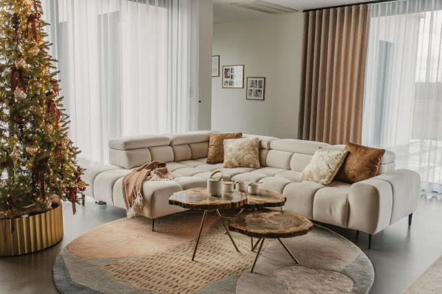 świąteczny dom z beżową kanapą i drewnem