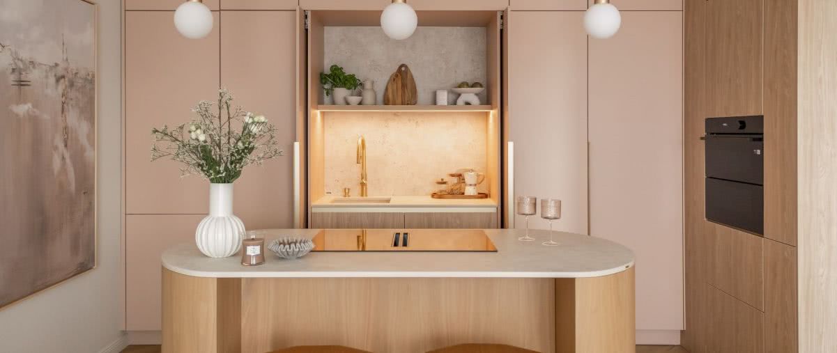 Przyjazna kuchnia z wyspą w dwóch kolorach: beż i róż otulają spokojem 