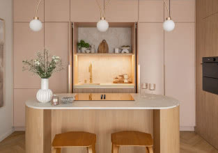 Przyjazna kuchnia z wyspą w dwóch kolorach: beż i róż otulają spokojem
