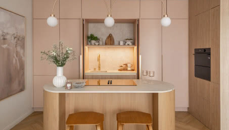 Przyjazna kuchnia z wyspą w dwóch kolorach: beż i róż otulają spokojem