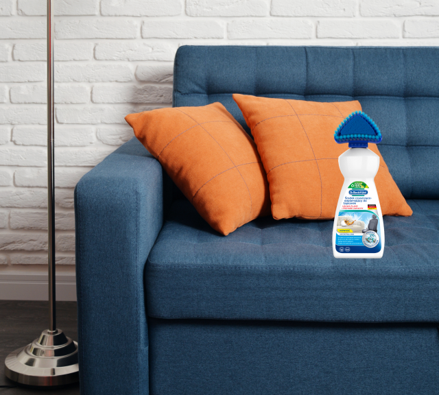 kanapa, biała cegła na ścianie, poduszki ozdobne, płyn do czyszczenia tapicerek, lampa podłogowa