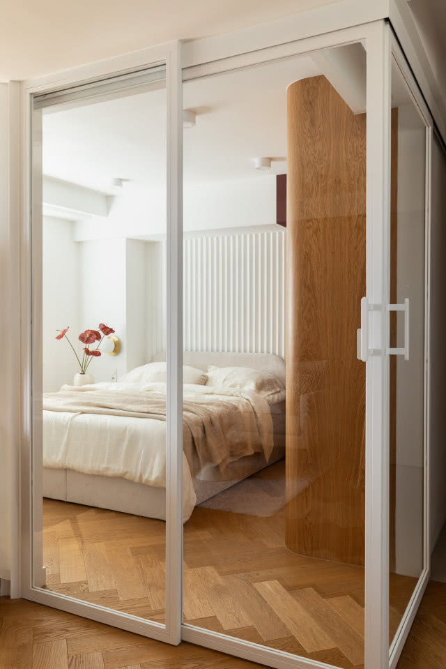 sypialnia wydzielona w salonie szklanymi drzwiami