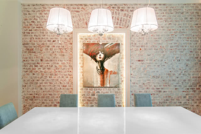 cegła na ścianie, obraz, oświetlenie sufitowe, duży stół z krzesłami