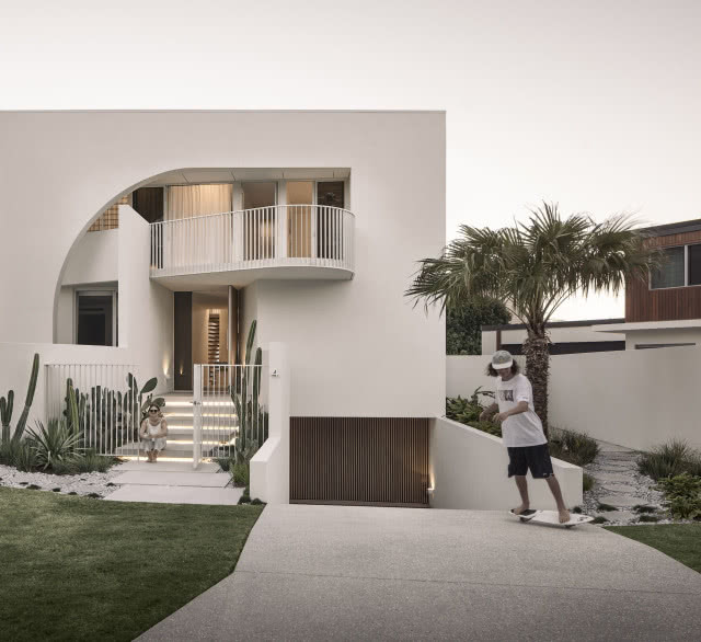 Syn właścicieli na deskorolce przed wjazdem do garażu