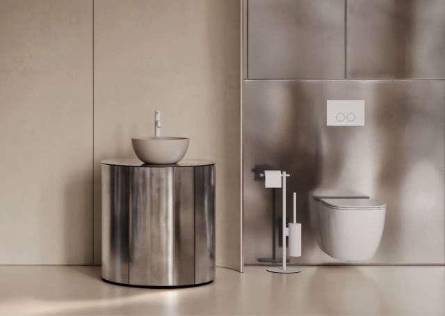 Minimalistyczna łazienka: podwieszana toaleta, metaliczna ściana i umywalka na cylindrycznej szafce