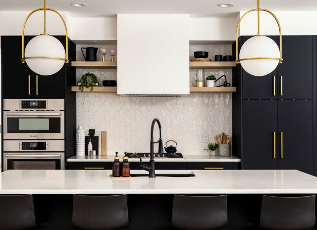 czarne matowe fronty kuchenne, drewniane półki, czarna bateria zlewozmywakowa, płyta gazowa, piekarnik, biały okap, lampy wiszące