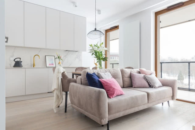 Minimalistyczna kuchnia w białym kolorze otwarta na salon