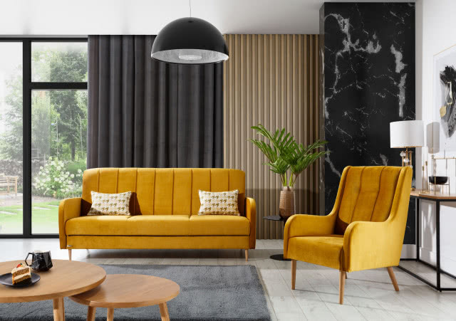 wersalka w kolorze musztardowym, fotel , stolik kawowy, stolik pod kwiat doniczkowy, lamele na ścianie, ciemne zasłony, duże okna, stolik na lampkę, dywan, panele podłogowe, kamień na ścianie, lampa sufitowa