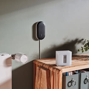 komoda, oczyszczacz powietrza, klimatyzacja, drewno na ścianie, drewniane panele na podłodze, okno balkonowe, świece, wazon z kwiatami