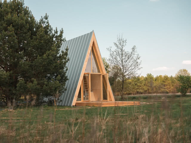 domek brda z przeszkloną ścianą i dużym tarasem