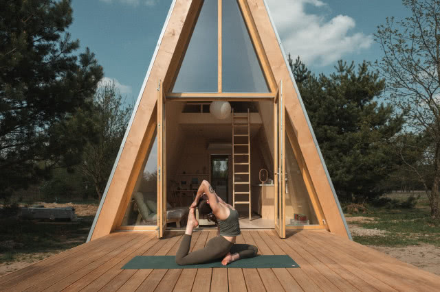 domek brda z przeszkloną ścianą i dużym tarasem