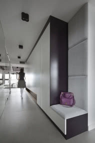 Wzdłuż korytarza zaprojektowano szafy, które tworzą gładką powierzchnię.