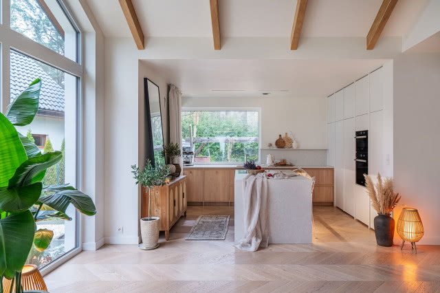 wyspa kuchenna, belki na suficie, jodełka na podłodze, dywanik, kwiaty