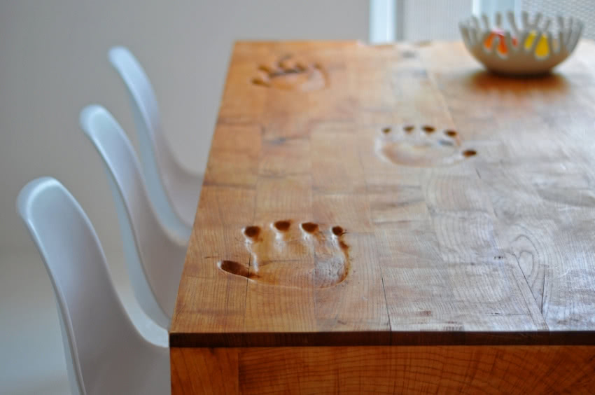 Drewniany stół z wyrzeźbionymi "odciskami" dłoni...