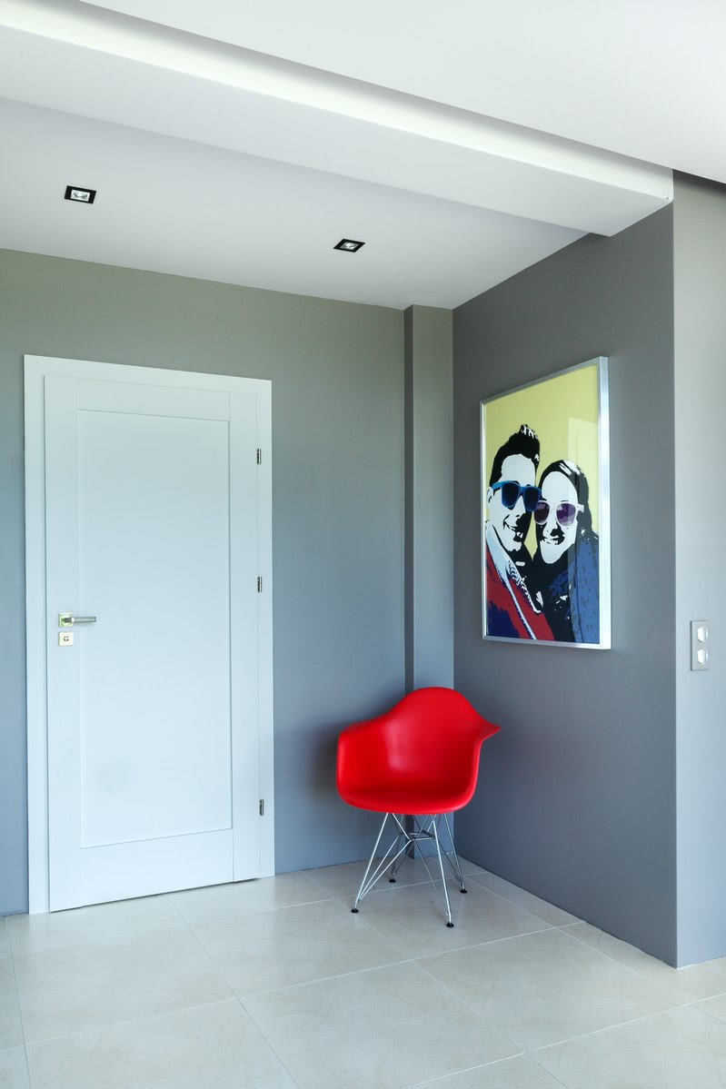 Szare ściany przedpokoju są świetnym tłem dla...