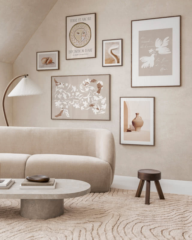 salon w beżach, na ścianie kilka obrazów powieszonych obok siebie 