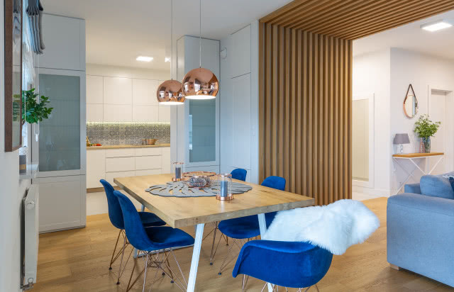 Granatowe krzesła i miedziane lampy wiszące