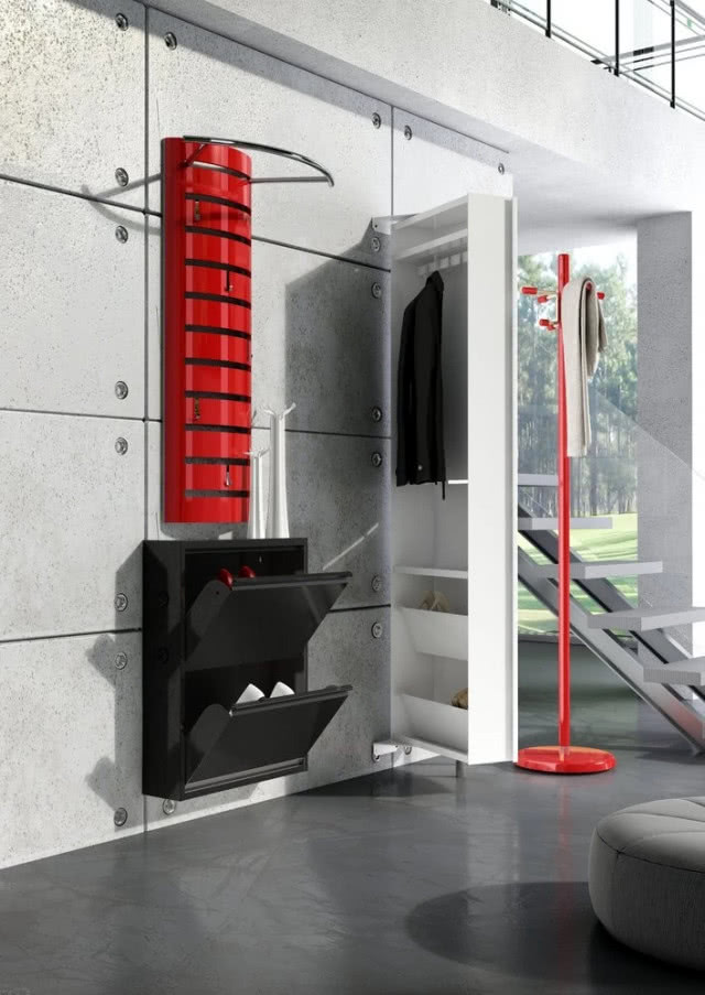 Kolekcja mebli Home, elementy wykonane z blachy stalowej, lakierowanej na różne kolory. Szafka wisząca na buty z dwoma szufladami (szer. 51 cm, gł. 15 cm, wys. 73 cm). Wieszak naścienny, czerwony (szer. 63 cm, gł. 35 cm, wys. 112 cm). Szafa obrotowa, wykończona białym lakierem (szer. 54 cm, gł. 39 cm, wys. 190 cm). Wieszak wolno stojący, o wys. 180 cm. ALL HALL