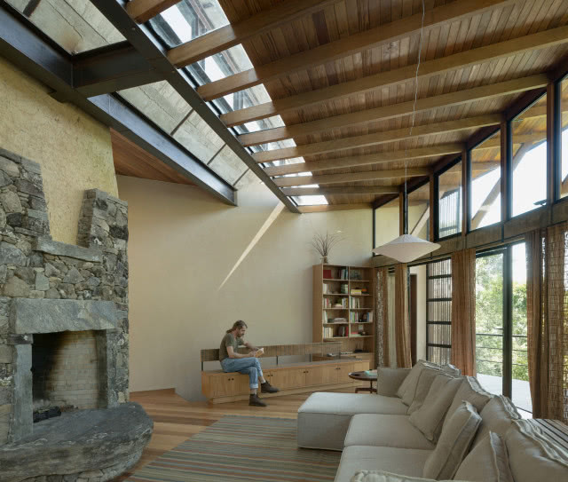 fragment kominka, mężczyzna siedzi na drewnianej ławie