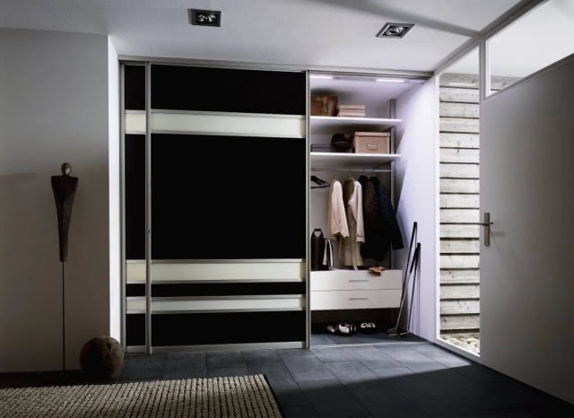 Szafa przedpokojowa z drzwiami przesuwanymi, system 3000, drzwi w ramie aluminiowej wypełnionej czarną i białą płyta meblową, wyposażenie szafy to modułowy  system Uno. RAUMPLUS