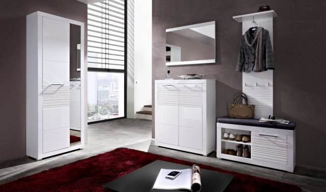 Przedpokój urządzony meblami Flames, kolor biały mat/biały połysk. W skład zestawu wchodzą: szafka (szer. 72 cm, gł. 37 cm, wys. 201 cm), szafka na buty (szer. 92 cm, gł. 37 cm, wys. 50 cm), szafka (szer. 92 cm, gł. 37 cm, wys. 110 cm), wieszak (szer. 39 cm, gł. 39 cm, wys. 151 cm) oraz lustro (szer. 92 cm, wys. 66 cm) BLACK RED WHITE